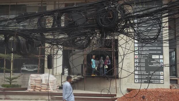 View of tangled overhead wires in front of a building Bangladesh.