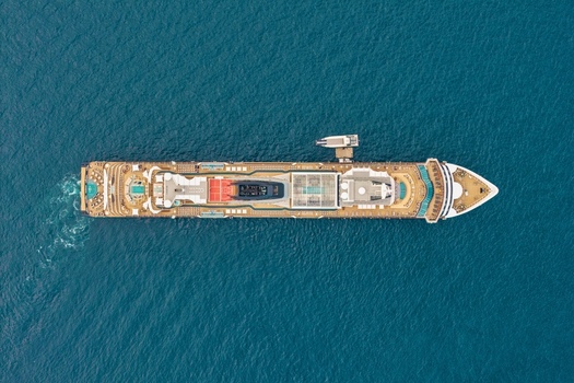 Aerial view of a large cruise ship sailing near the coast of Ile Sainte Marguerite showing the deck layout swimming pools and deep blue sea in Cannes Provence Alpes Cote d Azur France. Aerial view of a large cruise ship sailing near the coast of Ile Sainte Marguerite showing the deck layout swimming pools and deep blue sea in Cannes Provence Alpes Cote d Azur France.