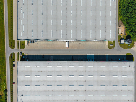 Aerial view of a large industrial warehouse complex with loading docks parking areas and surrounding green landscape in Lielvarzi Kekava Municipality Latvia. Aerial view of a large industrial warehouse complex with loading docks parking areas and surrounding green landscape in Lielvarzi Kekava Municipality Latvia.