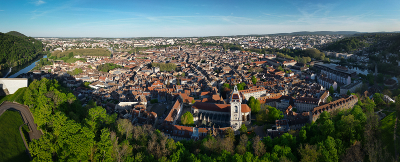 Aerial view of the Besancon Citadel and the historic old town with red tiled roofs and lush green hills under a clear blue sky in Besancon Bourgogne Franche Comte France. Aerial view of the Besancon Citadel and the historic old town with red tiled roofs and lush green hills under a clear blue sky in Besancon Bourgogne Franche Comte France.