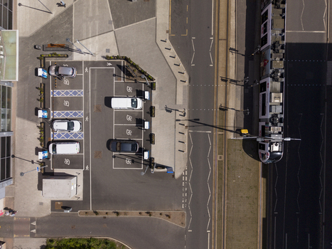 Edinburgh United Kingdom 06 May 2026 Aerial view of an electric vehicle charging hub with parked cars and a tram passing by on a sunny day. Edinburgh United Kingdom 06 May 2026 Aerial view of an electric vehicle charging hub with parked cars and a tram passing by on a sunny day.