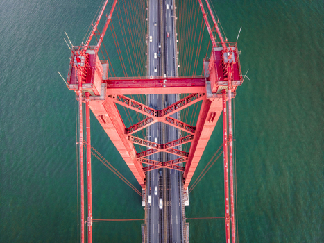 Panoramic aerial view of the highway road on April 25th bridge crossing Tagus river with Lisbon downtown in background Lisbon Portugal.