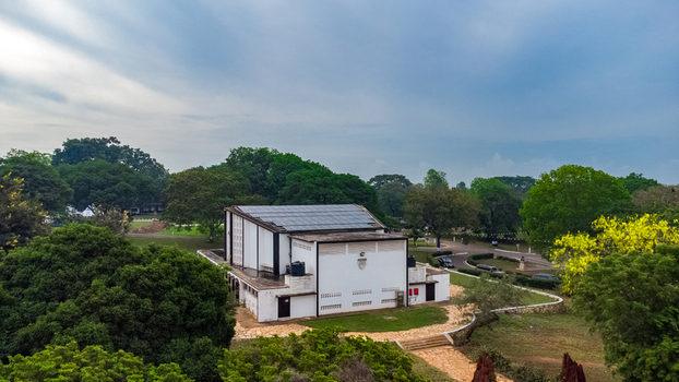 Aerial view of Achimota School building with solar panels on the roof surrounded by lush green trees and a paved path in Achimota Greater Accra Region Ghana. Aerial view of Achimota School building with solar panels on the roof surrounded by lush green trees and a paved path in Achimota Greater Accra Region Ghana.