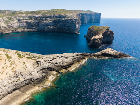 Aerial view of Dwejra Bay and Fungus Rock with high limestone cliffs and turquoise Mediterranean sea in Gozo Region Malta. Aerial view of Dwejra Bay and Fungus Rock with high limestone cliffs and turquoise Mediterranean sea in Gozo Region Malta.