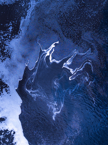 Aerial view of swirling white foam patterns on the dark blue surface of the Kalgan River near the Upper Kalgan Bridge in Kalgan Western Australia Australia. Aerial view of swirling white foam patterns on the dark blue surface of the Kalgan River near the Upper Kalgan Bridge in Kalgan Western Australia Australia.