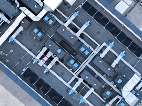 Aerial view of a modern industrial rooftop featuring extensive HVAC ventilation systems cooling units and integrated solar panel arrays in Krakow Lesser Poland Voivode Poland. Aerial view of a modern industrial rooftop featuring extensive HVAC ventilation systems cooling units and integrated solar panel arrays in Krakow Lesser Poland Voivode Poland.