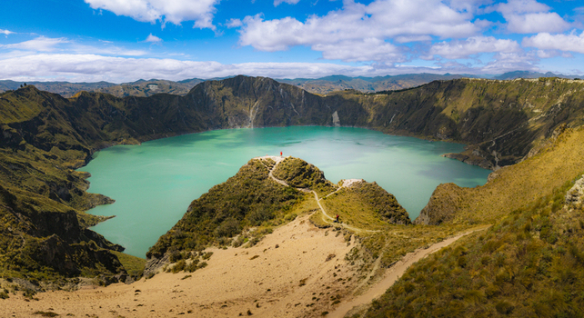 Aerial view of Quilotoa Lake with its vibrant turquoise water inside a volcanic crater surrounded by steep rugged slopes and hiking trails Quilotoa Cotopaxi Ecuador. Aerial view of Quilotoa Lake with its vibrant turquoise water inside a volcanic crater surrounded by steep rugged slopes and hiking trails Quilotoa Cotopaxi Ecuador.