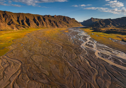Aerial view of the braided river channels winding through the mountainous landscape near Kol Suu in At Bashi District Naryn Region Kyrgyzstan. Aerial view of the braided river channels winding through the mountainous landscape near Kol Suu in At Bashi District Naryn Region Kyrgyzstan.