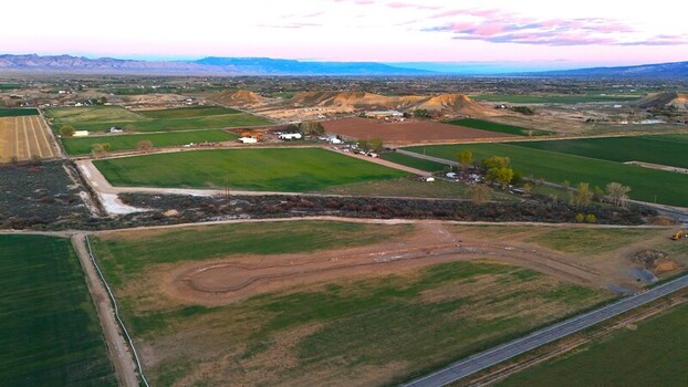 Aerial view of lush green agricultural fields and rural landscapes with distant mountains under a soft twilight sky in Loma Colorado United States. Aerial view of lush green agricultural fields and rural landscapes with distant mountains under a soft twilight sky in Loma Colorado United States.