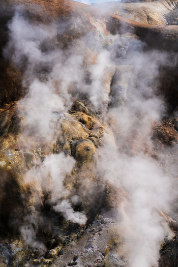 View of rising steam and geothermal activity paints the rugged landscape in shades of ochre and grey creating an otherworldly scene in Hrunamannahreppur Hrunamannahreppur Iceland.
