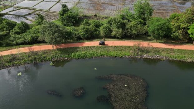 Aerial view of a tuk tuk on a dirt road in Sri Lanka.