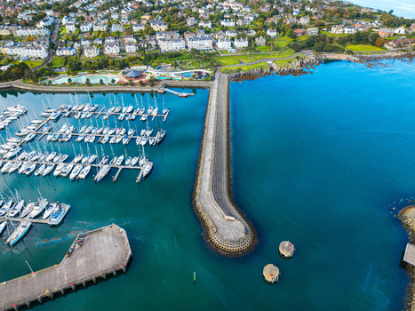 Aerial view of Bangor Harbour and Town featuring a marina filled with boats a long stone breakwater and the coastal town buildings in Bangor Northern Ireland United Kingdom.
