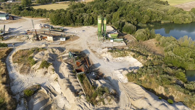Aerial view of the Extraccion de aridos Lima SL sand and gravel extraction site with industrial silos conveyor belts and sand piles near a lake in Vilarino das Poldras Ourense Spain. Aerial view of the Extraccion de aridos Lima SL sand and gravel extraction site with industrial silos conveyor belts and sand piles near a lake in Vilarino das Poldras Ourense Spain.