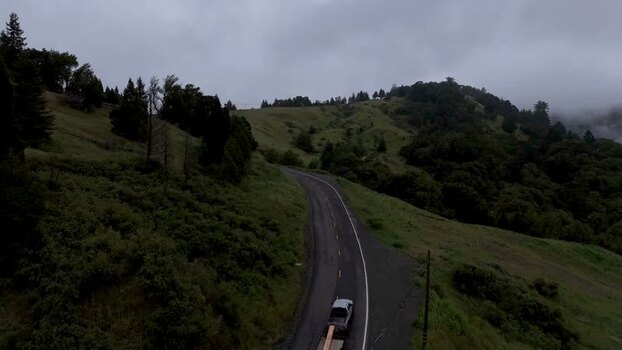 Aerial view of a truck on a winding road through hills United States. Aerial view of a truck on a winding road through hills United States.
