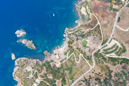 Aerial view of Riserva Naturale Orientata dello Zingaro featuring rugged coastal cliffs turquoise waters winding roads and lush vegetation in San Vito Lo Capo Sicilia Italy. Aerial view of Riserva Naturale Orientata dello Zingaro featuring rugged coastal cliffs turquoise waters winding roads and lush vegetation in San Vito Lo Capo Sicilia Italy.