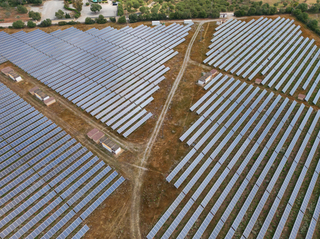 Aerial view of a large solar farm with rows of photovoltaic panels on dry land surrounded by trees in Manacor Balearic Islands Spain. Aerial view of a large solar farm with rows of photovoltaic panels on dry land surrounded by trees in Manacor Balearic Islands Spain.