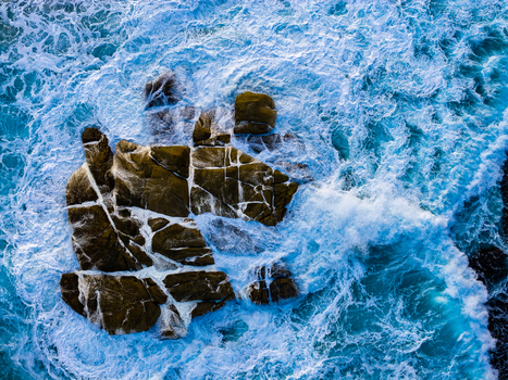 Aerial view of rugged rocky outcrops surrounded by crashing turquoise ocean waves and white sea foam in Torndirrup Western Australia Australia. Aerial view of rugged rocky outcrops surrounded by crashing turquoise ocean waves and white sea foam in Torndirrup Western Australia Australia.