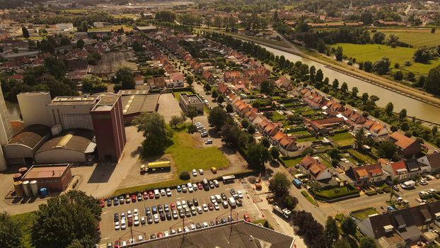 Aerial view of industrial buildings a parking lot residential houses with red tiled roofs and a canal in Saint Omer Hauts de France France. Aerial view of industrial buildings a parking lot residential houses with red tiled roofs and a canal in Saint Omer Hauts de France France.