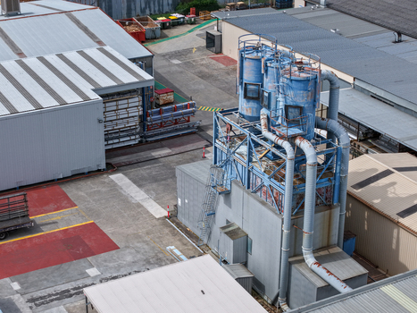 Melbourne VIC Australia 25 September 2026 Aerial view of an industrial factory site featuring large blue dust collection machinery metal ventilation pipes and concrete yards.
