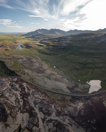 Aerial view of Ytri Raudarmelskula volcanic crater mossy lava fields winding river and distant mountains under a bright sky in Raudhamelur Eyja og Miklaholtshr Iceland. Aerial view of Ytri Raudarmelskula volcanic crater mossy lava fields winding river and distant mountains under a bright sky in Raudhamelur Eyja og Miklaholtshr Iceland.