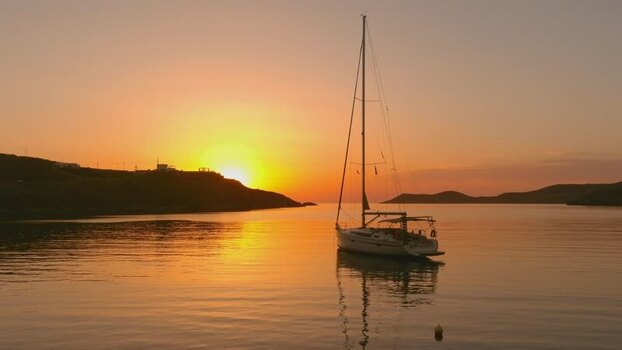 Aerial view of a sailboat in a calm bay at sunset Greece. Aerial view of a sailboat in a calm bay at sunset Greece.