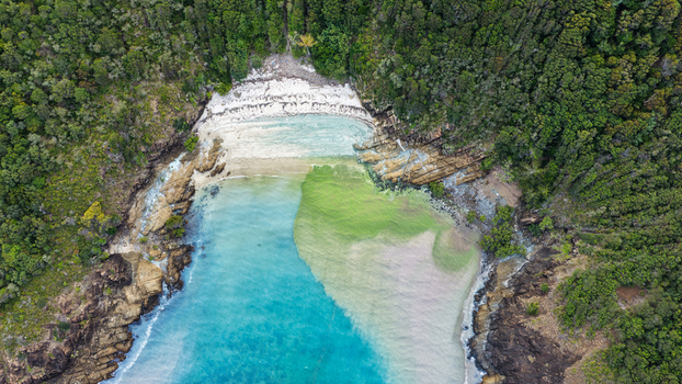 Aerial view of Chance Bay with turquoise water rocky cliffs and dense forest in Whitsundays Queensland Australia. Aerial view of Chance Bay with turquoise water rocky cliffs and dense forest in Whitsundays Queensland Australia.