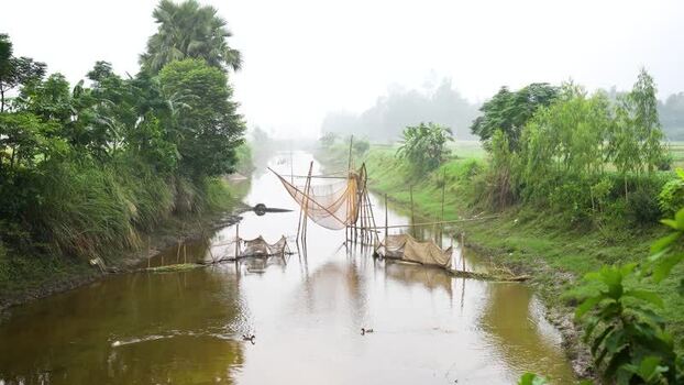 View of a traditional fishing net in a rural canal Bangladesh.