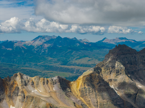 Aerial view of Mount Sneffels and the rugged peaks of the San Juan Mountain Range featuring dramatic rocky slopes and deep valleys in Ouray Colorado United States. Aerial view of Mount Sneffels and the rugged peaks of the San Juan Mountain Range featuring dramatic rocky slopes and deep valleys in Ouray Colorado United States.
