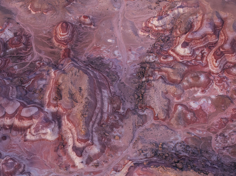 Aerial view of the colorful Bentonite Hills featuring distinct red purple and white clay layers eroded ridges and desert terrain in Hanksville Utah United States.