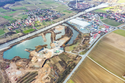 Aerial view of a gravel pit with turquoise water next to a river industrial zones and residential areas in Forchheim Bavaria Germany. Aerial view of a gravel pit with turquoise water next to a river industrial zones and residential areas in Forchheim Bavaria Germany.