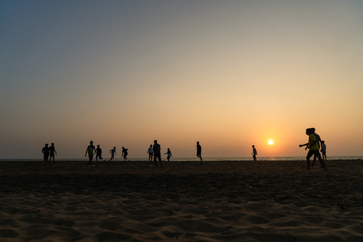 View of silhouettes of people playing football on a sandy beach during a vibrant sunset over the ocean Galle Southern Province Sri Lanka.