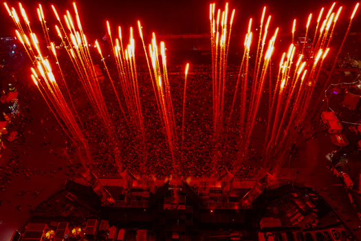 Herzogenaurach Germany 26 July 2025 Aerial view of Open Beatz Festival with a massive crowd and red fireworks illuminating the night sky.
