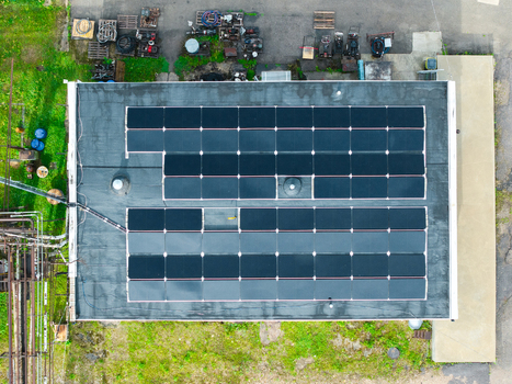 Aerial view of solar panels installed on a flat industrial roof with surrounding green vegetation in Olaine Olaine Municipality Latvia. Aerial view of solar panels installed on a flat industrial roof with surrounding green vegetation in Olaine Olaine Municipality Latvia.