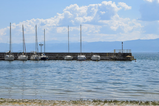 View of sailboats moored at the stone pier on Lake Ohrid in Ohrid Municipality of Ohrid North Macedonia. View of sailboats moored at the stone pier on Lake Ohrid in Ohrid Municipality of Ohrid North Macedonia.