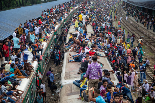 Dhaka Bangladesh 15 June 2018 View of Airport Railway Station crowded with thousands of passengers sitting on train roofs and standing on tracks during the holiday rush. Dhaka Bangladesh 15 June 2018 View of Airport Railway Station crowded with thousands of passengers sitting on train roofs and standing on tracks during the holiday rush.