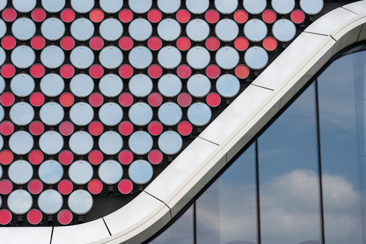 Aerial view of the modern facade of Holland Casino Venlo featuring a pattern of red and white circular elements and curved architectural lines in Venlo Limburg Netherlands. Aerial view of the modern facade of Holland Casino Venlo featuring a pattern of red and white circular elements and curved architectural lines in Venlo Limburg Netherlands.