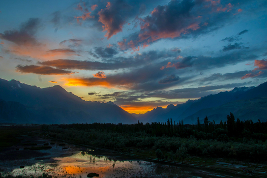 View of the Katpana Desert and Indus River valley at sunset with dramatic clouds reflecting in the water and silhouetted mountains Skardu Gilgit Pakistan. View of the Katpana Desert and Indus River valley at sunset with dramatic clouds reflecting in the water and silhouetted mountains Skardu Gilgit Pakistan.