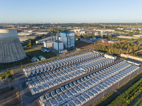 Aerial view of the Cargovil battery energy storage system with rows of white storage units adjacent to a cooling tower and industrial infrastructure in Vilvoorde Vlaanderen Belgium. Aerial view of the Cargovil battery energy storage system with rows of white storage units adjacent to a cooling tower and industrial infrastructure in Vilvoorde Vlaanderen Belgium.