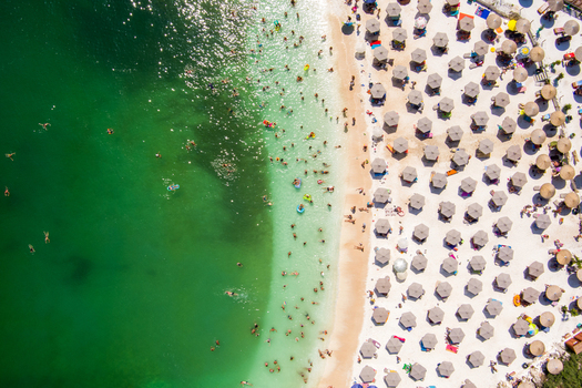 Greece 21 September 2026 Aerial view of a crowded beach with rows of sun umbrellas on the white sand and people swimming in the clear turquoise sea. Greece 21 September 2026 Aerial view of a crowded beach with rows of sun umbrellas on the white sand and people swimming in the clear turquoise sea.