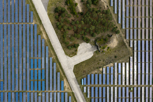 Aerial view of the solar field at the former military airfield Preschen with rows of solar panels historic hangars and a concrete runway in Neisse Malxetal Brandenburg Germany. Aerial view of the solar field at the former military airfield Preschen with rows of solar panels historic hangars and a concrete runway in Neisse Malxetal Brandenburg Germany.