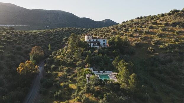 Aerial view of a white villa with a pool on a hillside Spain.