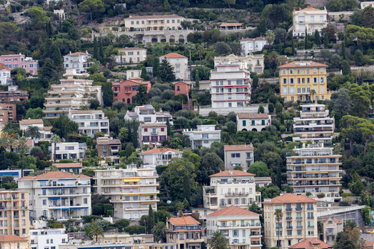 Aerial view of residential buildings nestled on a hillside with lush Mediterranean vegetation in Nice Provence Alpes Cote dAzur France. Aerial view of residential buildings nestled on a hillside with lush Mediterranean vegetation in Nice Provence Alpes Cote dAzur France.