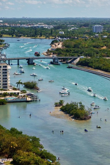 Aerial view of boats cruising on turquoise water near a bridge and lush tropical shorelines Jupiter Florida United States. Aerial view of boats cruising on turquoise water near a bridge and lush tropical shorelines Jupiter Florida United States.