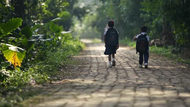 View of school children walking on a rural path Bangladesh.