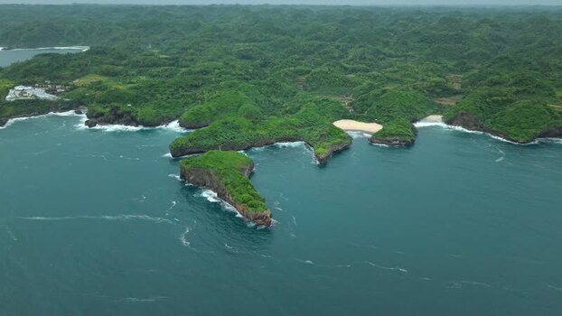 Aerial view of Sedahan Beach and lush green cliffs Indonesia.