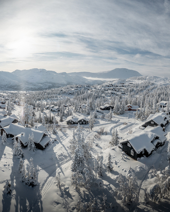Aerial view of Gaustablikk Fjellresort featuring snow covered cabins nestled among pine trees in the winter landscape of Rjukan Telemark Norway. Aerial view of Gaustablikk Fjellresort featuring snow covered cabins nestled among pine trees in the winter landscape of Rjukan Telemark Norway.