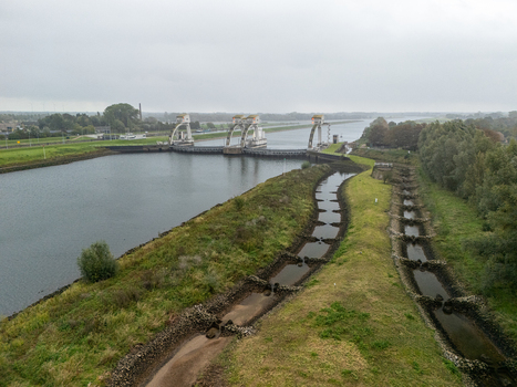 Aerial view of Sluis en stuwcomplex Hagestein with its distinctive weir gates spanning the Lek river surrounded by grassy banks and a fish ladder in Hagestein Utrecht Netherlands.