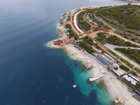 Aerial view of the coastline in Ksamil featuring turquoise waters sandy beaches and coastal development along the rugged terrain of Vlore County Albania. Aerial view of the coastline in Ksamil featuring turquoise waters sandy beaches and coastal development along the rugged terrain of Vlore County Albania.