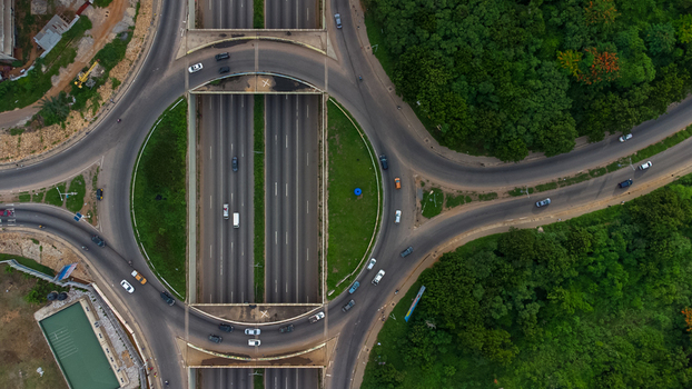 Accra Ghana 02 June 2023 Aerial view of Forever roundabout featuring multi lane roads surrounding lush green vegetation and vehicles navigating the interchange. Accra Ghana 02 June 2023 Aerial view of Forever roundabout featuring multi lane roads surrounding lush green vegetation and vehicles navigating the interchange.