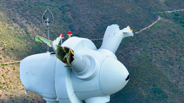 Aerial view of a damaged wind turbine with a broken blade and structural damage situated in a hilly landscape in Lisbon Lisbon Portugal. Aerial view of a damaged wind turbine with a broken blade and structural damage situated in a hilly landscape in Lisbon Lisbon Portugal.